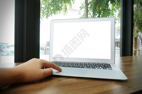 咖啡馆前面的木制桌子上有空白屏幕的笔记本电脑技术概念图片