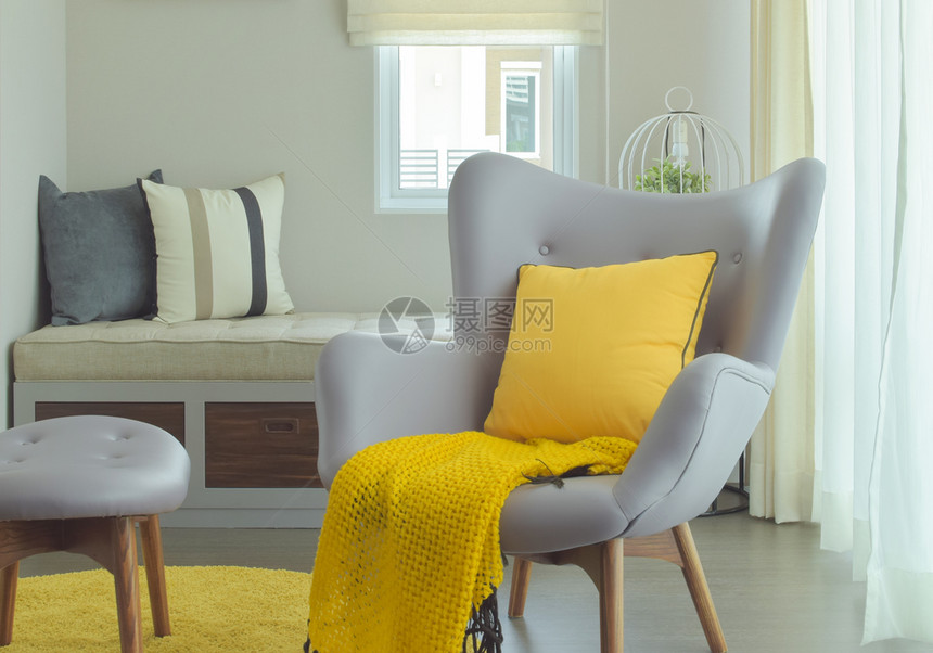 现代式生活角的臂椅黄色枕头和围巾图片