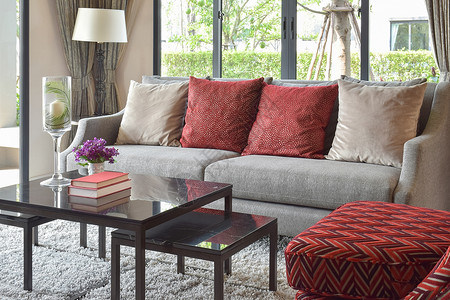 现代客厅设计在沙发和装饰桌灯上配有红色枕头图片