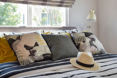 室内时髦的卧床和装饰桌灯上有黑色和白的枕头图片