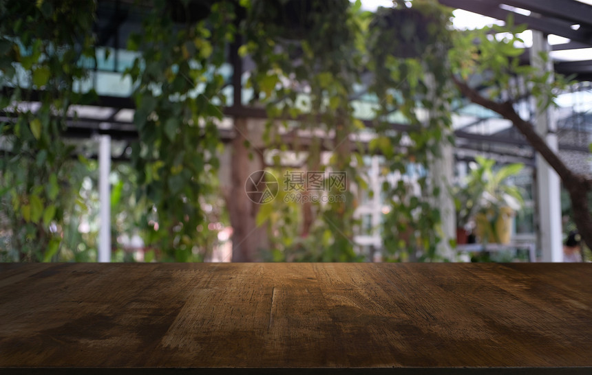在户外花园灯光的抽象模糊背景前的木制桌面图像可用于显示或装配您的产品图片