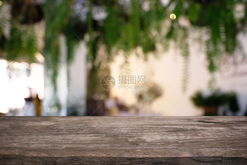 在户外花园灯光的抽象模糊背景前的木制桌子图像可以用于显示或装配您的产品图片