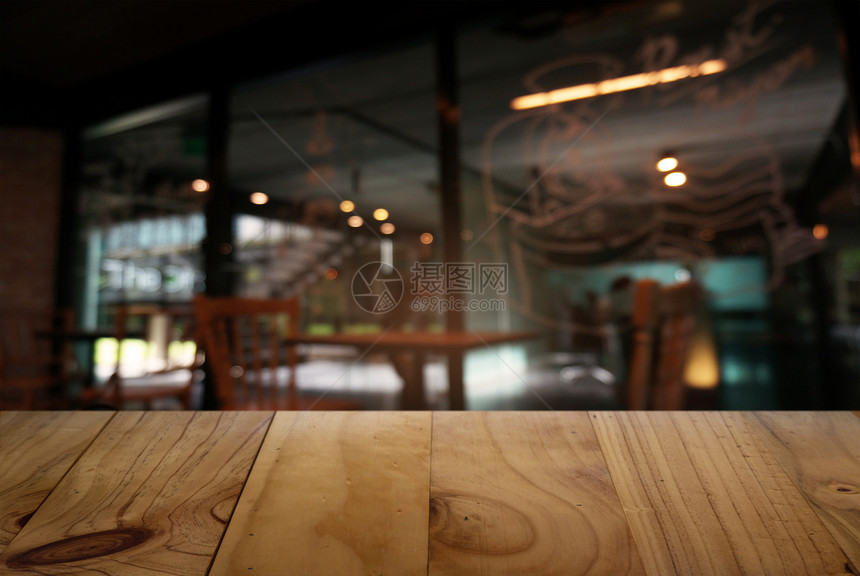 餐厅的抽象模糊背景面前的空木桌可以用于显示或更新产品图片