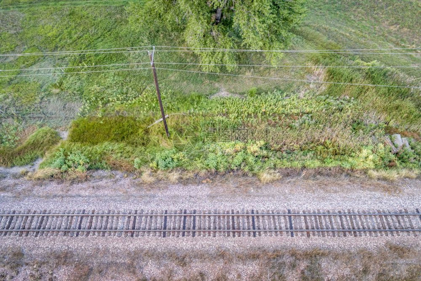 后单一铁路轨道和电线的空中观察图片