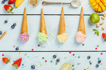红锥形草莓紫色蓝绿白茶石灰和黄色芒果香蕉的冰淇淋口味以蓝木本底为图片