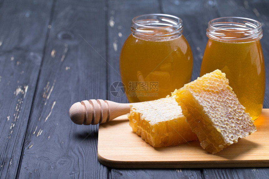蜂蜜背景玻璃罐里的甜蜜木制背景图片