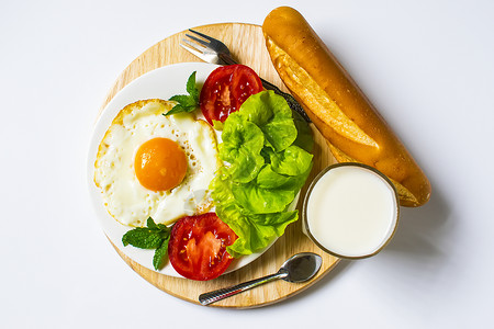 面包炒鸡蛋牛奶和蔬菜以及白底煎番茄饼早餐高清图片