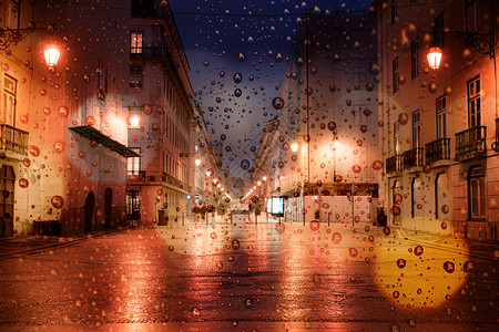 晚上在城里下雨街上交通车和城市灯光图片