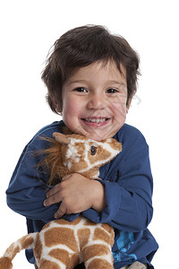 一个两岁男孩的肖像将玩具长颈鹿抱在白色背景上图片