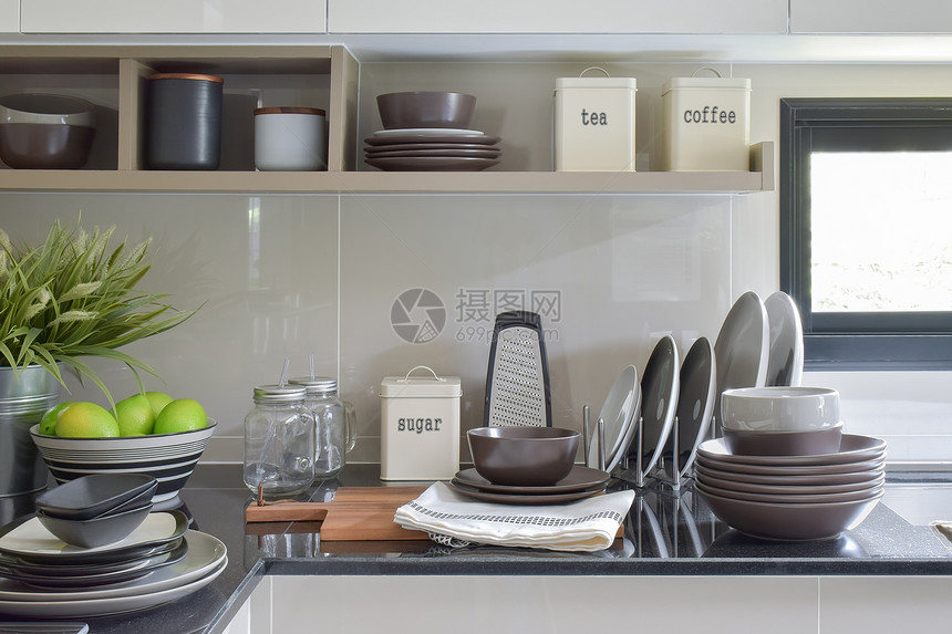现代厨房柜台和架上的陶瓷盘和碗图片