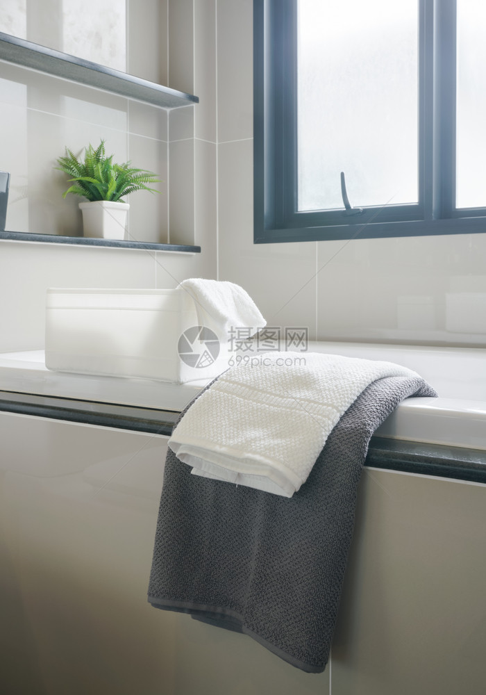 现代室内洗手间灰色和白毛巾浴缸图片
