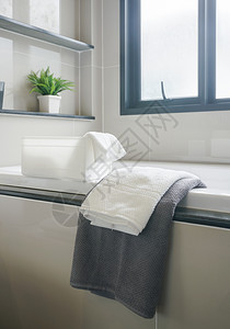 现代室内洗手间灰色和白毛巾浴缸图片