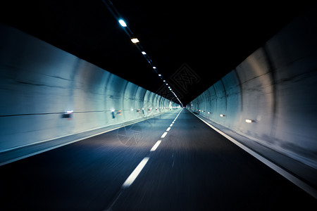 朝向开车穿过黑暗的现代城市隧道背景