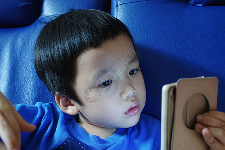 亚洲孩子盯着电话图片