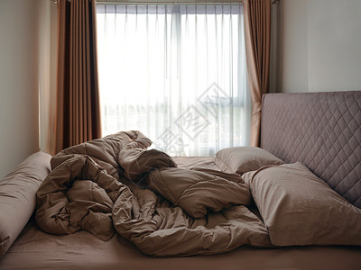 床铺垫和毯子在卧室里乱糟的图片