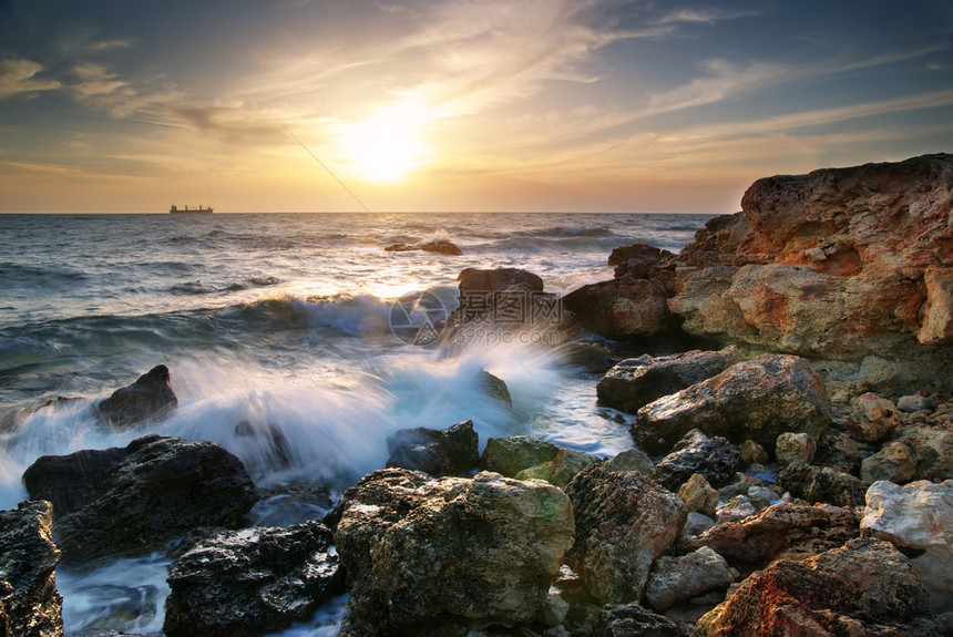 美丽的海景日落时与岩石自然构成图片