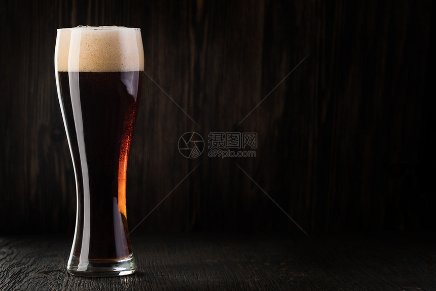 玻璃啤酒以木本为背景玻璃啤酒以木本为背景并有复制空间图片