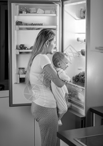 黑白照片有可爱宝的母亲晚上在冰箱里找吃的东西图片