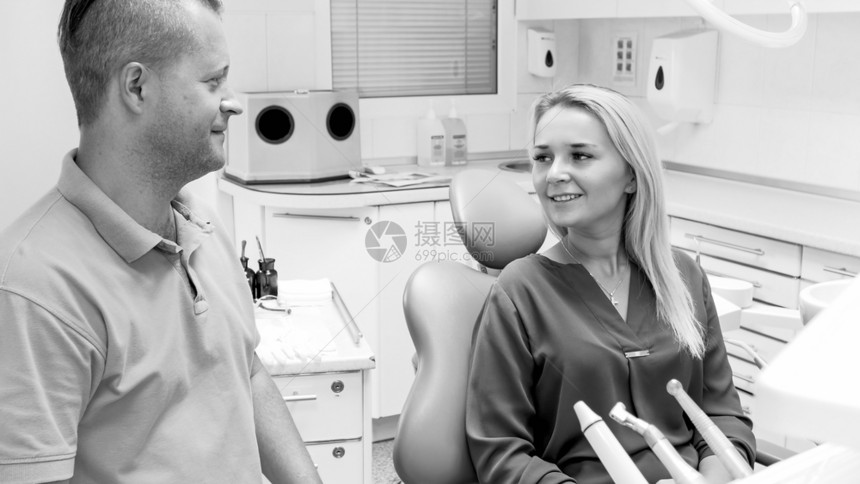 坐在诊所牙医椅上的美丽笑容女黑白形象图片