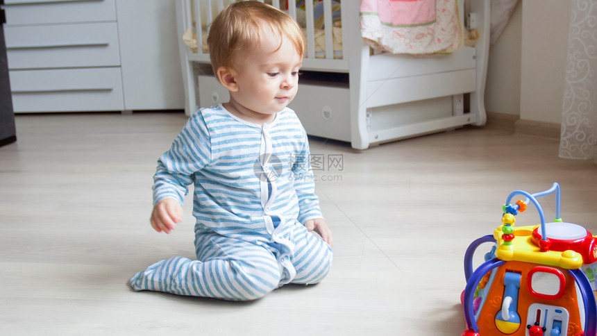 1岁的幼儿男孩在客厅的地板上玩耍1图片