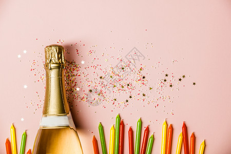 明星生日素材纯净的庆典香槟瓶加冰淇淋喷洒金星粉红色背景的生日蜡烛背景