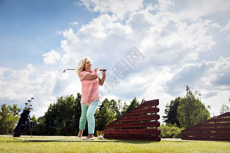 在高尔夫球场上打的活跃级女子夏季运动和爱好活跃的高级女子打尔夫背景图片