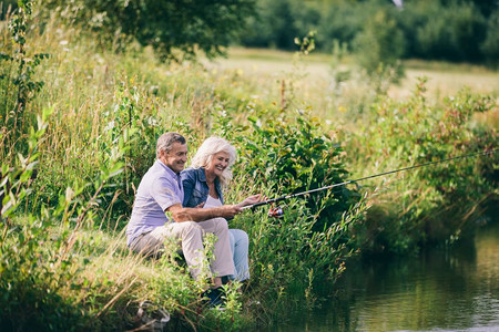 老夫妇在水边钓鱼幸福的关系夫妻活动在水边钓鱼图片