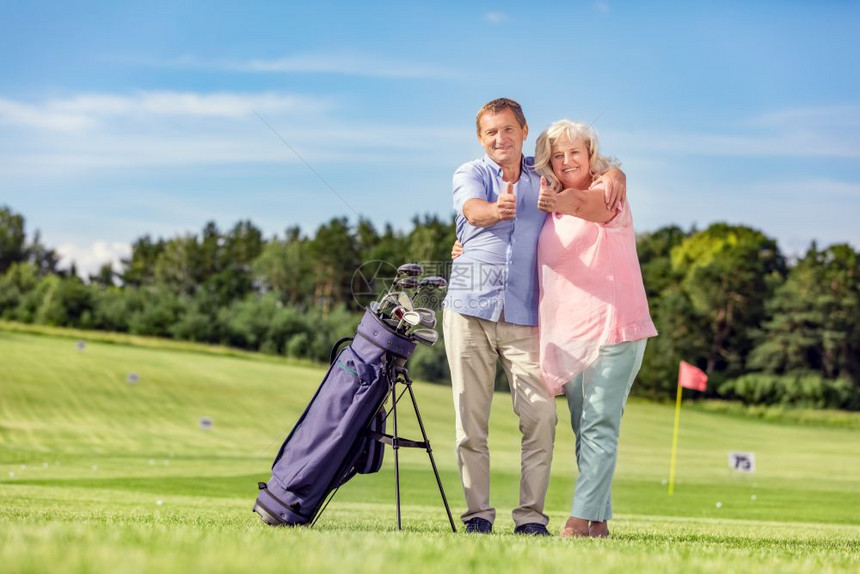 有吸引力的老年夫妇在高尔球场上伸出拇指幸福和满足感老年夫妇在高尔球场上伸出拇指图片