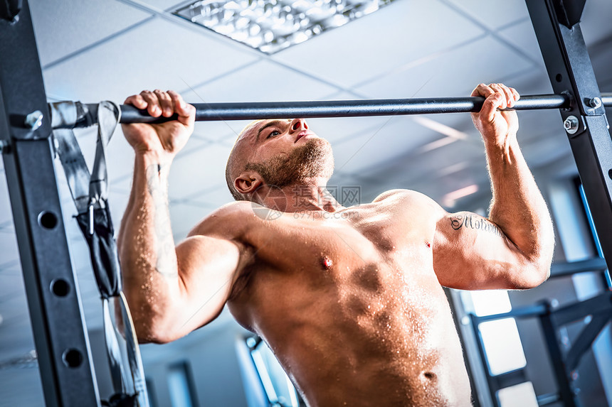 健身房的肌肉强者训练交叉下巴体操和脂肪燃烧图片