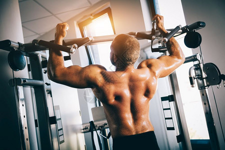 健硕的男人在健身房用器械锻炼肌肉图片