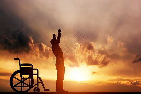 一个残疾人在日落时从轮椅上站起来治疗康复医奇迹希望保险等积极概念图片