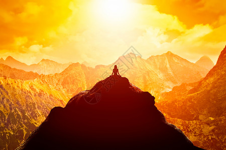 启蒙运动日落时在云顶的山上坐着瑜伽姿势Zen默思和平在日落时坐着瑜伽姿势背景