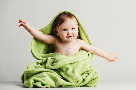 小孩穿绿毯子长着可笑的姿势快乐小孩可爱穿绿毯子的小孩图片
