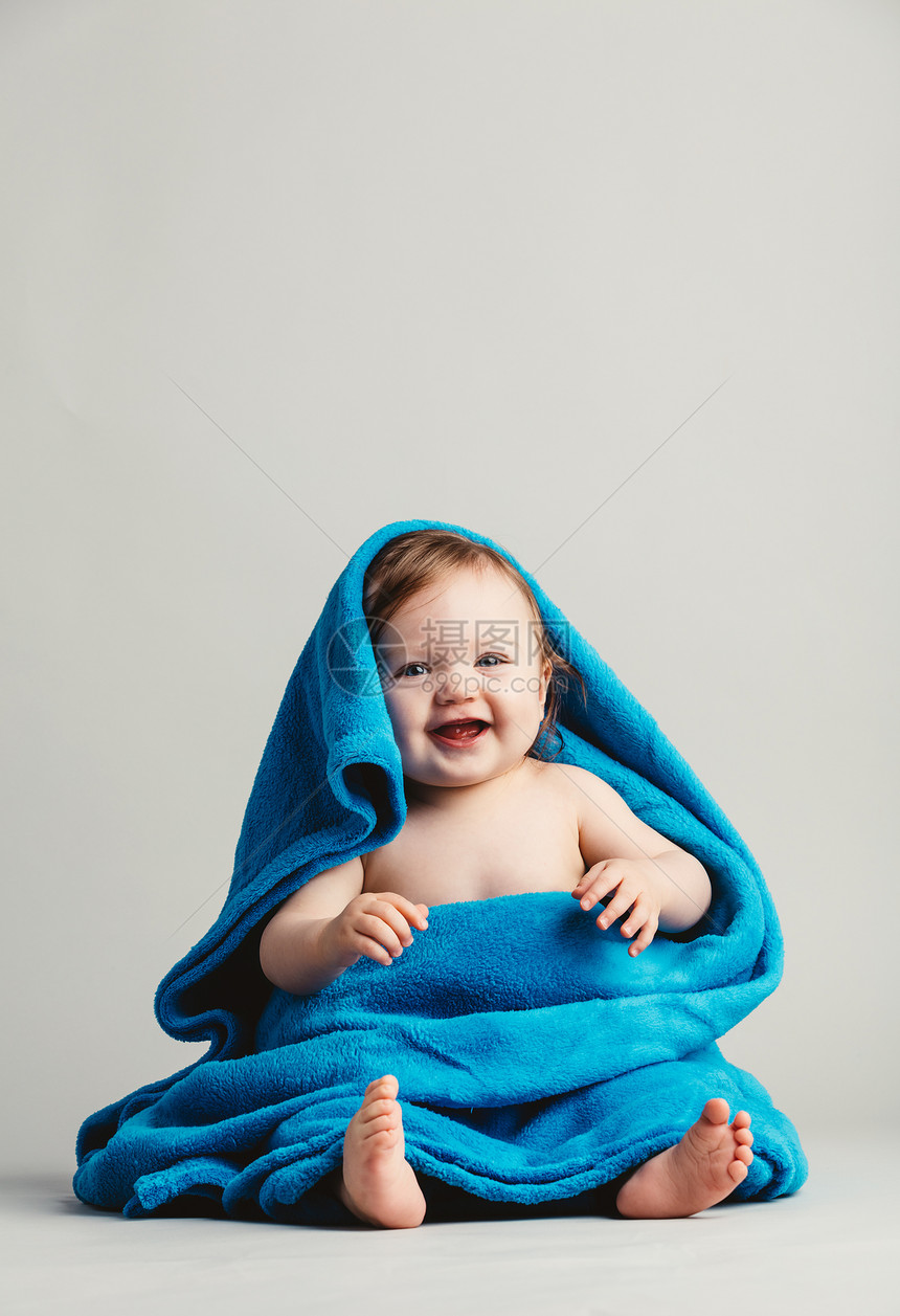 婴儿女孩睡在温暖的毯子里坐着微笑的小孩舒适微笑着的婴儿睡在温暖毯子里图片