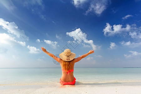 坐在马尔代夫热带海滩沙上快乐的坐在沙滩上马尔代夫热带海滩上快乐的沙图片