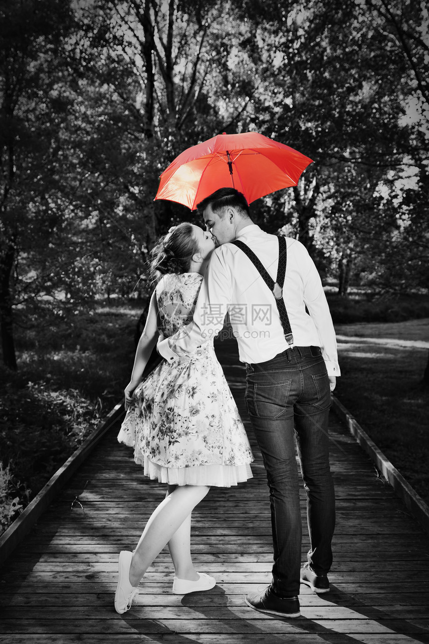 情侣在雨中调男人拿着红伞约会浪漫黑白红伞情侣图片