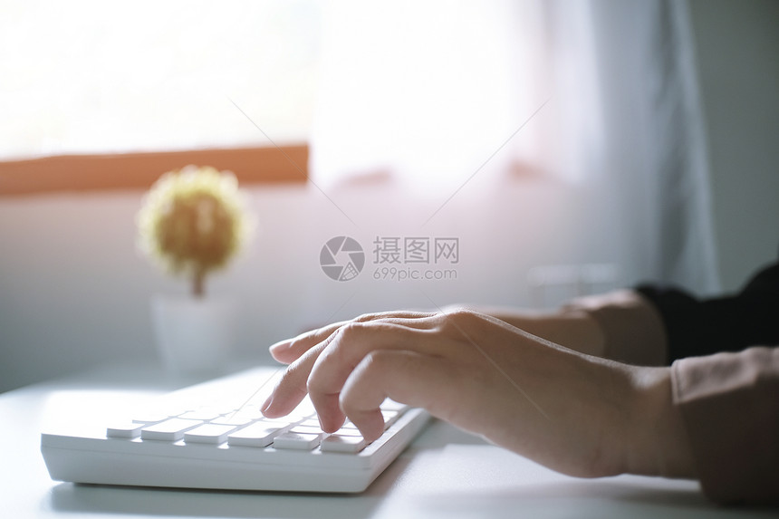 女人用笔记本电脑在木制桌上工作手打字在键盘上图片