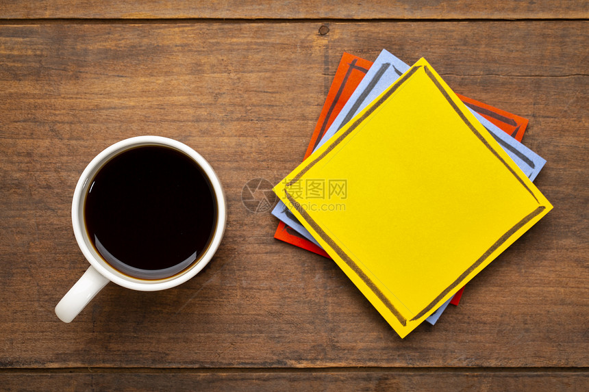 黄色空白提醒便条在配咖啡的黑木桌上加一杯咖啡图片