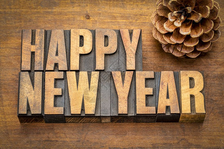新年快乐贺卡旧式纸质印刷板中的文字抽象词用松锥木制成的锈纸质印刷板图片
