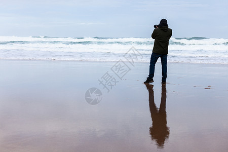摄影记者在暴风海沙滩的休光片图片