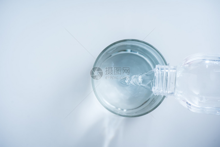 将水从瓶装倒入白底玻璃图片
