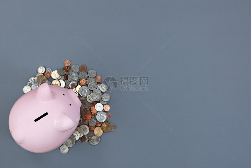 小猪银行和灰色桌面上硬币及复制空间图片