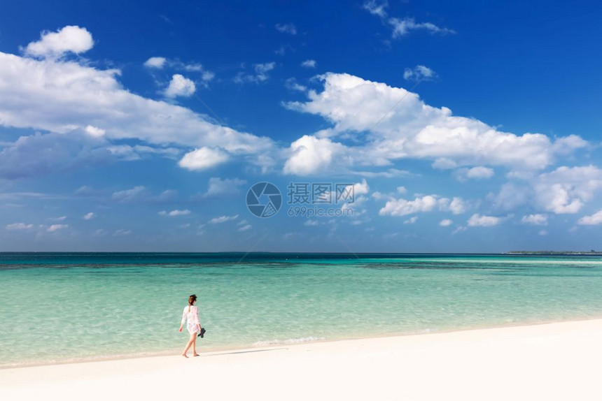 马尔代夫妇女在热带沙滩上行走图片