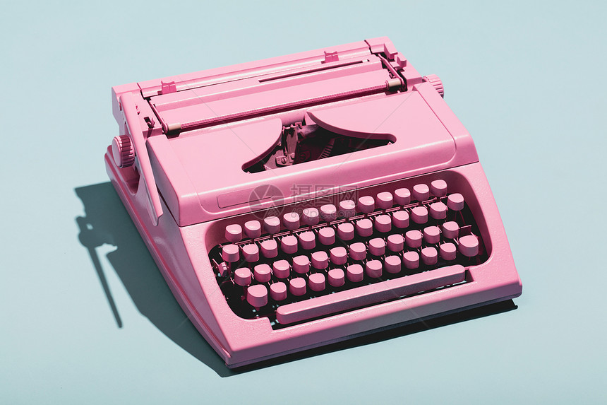 粉色打字机蓝糊面背景旧机器新闻图片