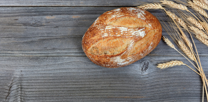 生锈木板上面包和小麦尾木板的全面包和小麦尾巴被烤成面包和小麦图片