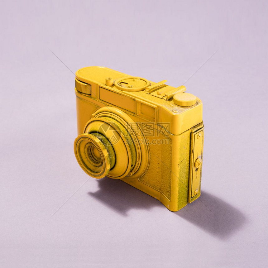 反向黄色相机站在粉红背景的糊贴上摄影概念粉红背景的贴上相机图片