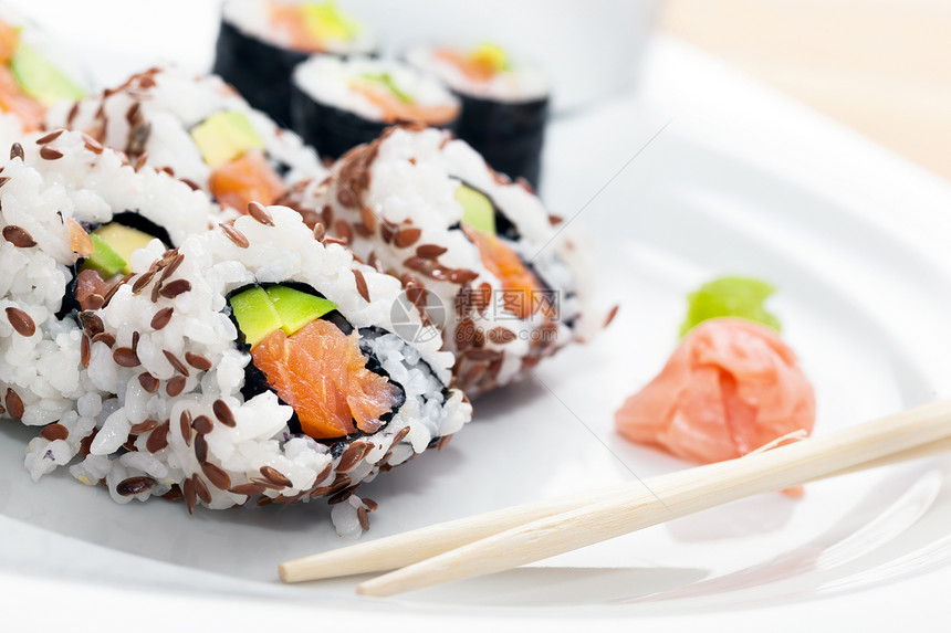 寿司加鲑鱼鳄梨海藻中的大米筷子加黄蜂和姜汁日本人亚洲健康食品寿司加鲑鱼海藻中的大米加黄蜂和姜汁图片