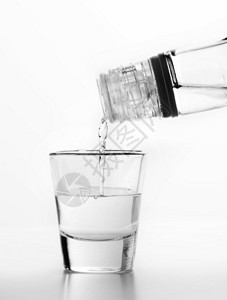 伏特加倒在玻璃上白色背景酒精概念图片