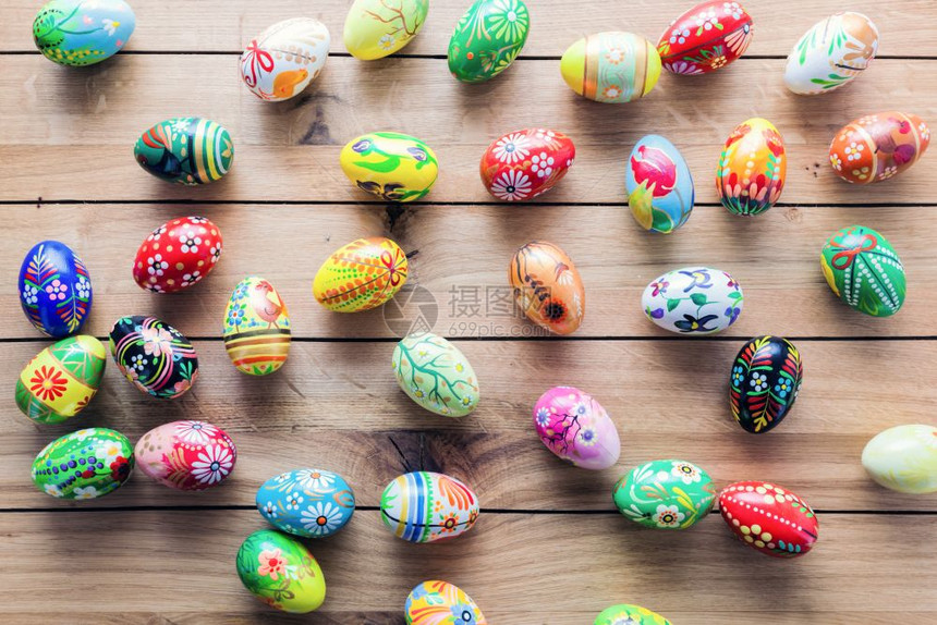 复活节手工制作的鸡蛋涂在木制桌子上传统装饰手工制作木桌子上的复活节手工制作的鸡蛋图片