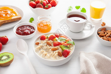 以燕麦粥草莓坚果吐司酱和茶品制成的健康早餐背景图片